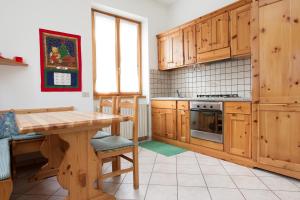 a kitchen with wooden cabinets and a wooden table at Casa Rico in Bormio