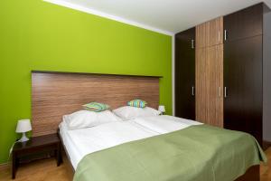 a green bedroom with a large bed with white pillows at Aparthotel Angel in Prague +8 photos