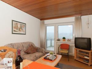 a living room with a couch and a tv at Serene Apartment in Meschede with Balcony in Grevenstein