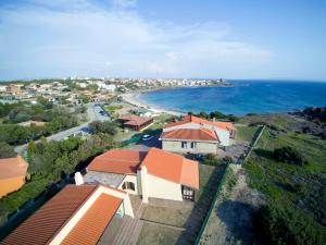 - une vue aérienne sur une maison et l'océan dans l'établissement La Baia Casa Vacanze, à Portoscuso