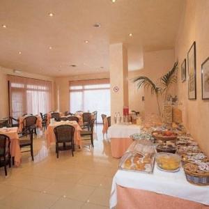 a large dining room with tables with food on them at Hotel La Corte in Rubiera