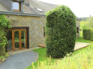 a large bush in front of a stone house at Charming Holiday Home in Halleux with Garden in Halleux