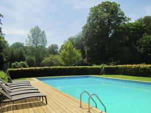 a swimming pool with two chairs on a wooden deck at Luxurious Castle with Private Pool and Sauna in Basse-Bodeux