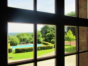 a window view of a pool from a house at Luxurious Castle with Private Pool and Sauna in Basse-Bodeux