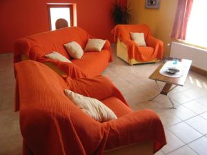 ウェームにあるQuaint Apartment in Ondenval with Terraceのリビングルーム(オレンジ色のソファ2台、テーブル付)