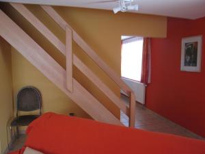 een slaapkamer met een trap en een rode muur bij Quaint Apartment in Ondenval with Terrace in Waimes