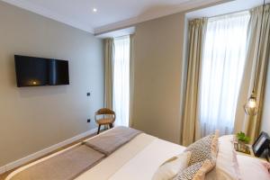 a bedroom with a bed and a television on the wall at Bairro Alto Suites in Lisbon