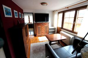 a living room with a tv and a couch and a table at Ferienhaus am Mühlenberg in Benz