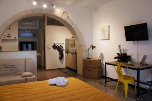 Schlafzimmer mit einem Bett, einem Tisch und einem Schreibtisch in der Unterkunft L'altro capo del filo in Syrakus