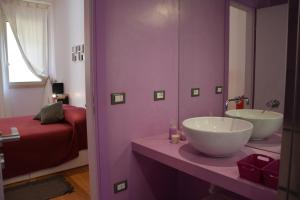un bagno viola con lavandino e specchio di Luci della città Palazzo San Matteo a Palermo Altre 38 foto