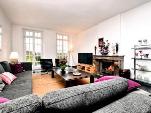 a living room with a couch and a fireplace at Charming holiday home in Ardennes with large garden in Honnay