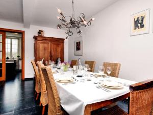 a dining room with a white table and chairs at Charming holiday home in Ardennes with large garden in Honnay