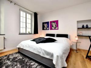 Un dormitorio con una gran cama blanca y una ventana en Charming holiday home in Ardennes and large garden, en Honnay