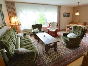 a living room with green couches and chairs and a table at Holiday home in Densborn with garden in Zendscheid