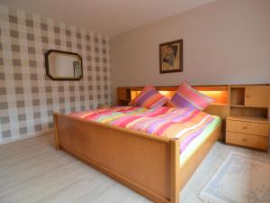 a bedroom with a wooden bed with a mirror at Holiday home in Densborn with garden in Zendscheid