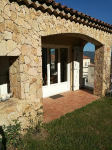 an entrance to a stone house with an open door at Corsica Monti Gite Appart in Petreto-Bicchisano +9 photos