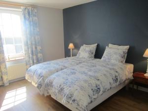 1 dormitorio con 1 cama con edredón azul y blanco en Welcoming Cottage in Offagne with Garden, en Offagne