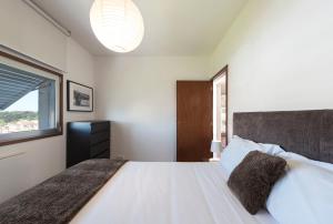 1 dormitorio con 1 cama blanca grande y ventana en LovelyStay - Casas Brancas - Modern Apartment with Balcony & free private parking, en Oporto
