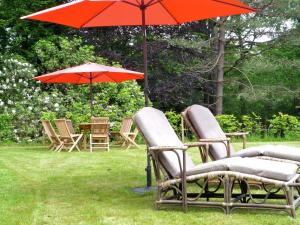 un grupo de sillas y una sombrilla en el césped en Villa in Spa with Sauna Recreation and Playroom, en Spa