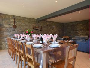 een lange tafel in een kamer met een stenen muur bij Spacious holiday home near Bastogne in Mande Saint-Étienne