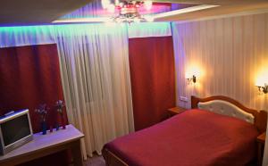 sypialnia z czerwonym łóżkiem i telewizorem w obiekcie ApartLux Chernigov w mieście Czernihów