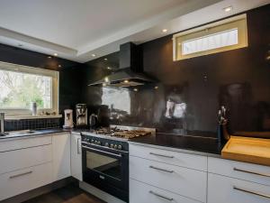 - une cuisine avec des murs noirs et une cuisinière four supérieur dans l'établissement Beautiful villa 200 metres from the sea, à Coxyde