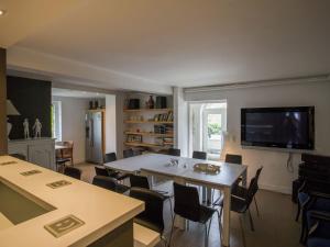 a living room with a table and chairs and a tv at Beautiful villa 200 metres from the sea in Koksijde