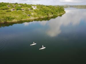 two people are in boats on a river at Naara Eco Lodge & Spa in Chidenguele