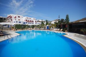 una gran piscina azul con edificios blancos en el fondo en Kamari Hotel, en Platis Gialos