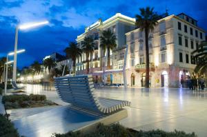 un banc devant un bâtiment la nuit dans l'établissement Magnolia Luxury Apartments, à Split