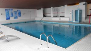 a large swimming pool with blue water in a building at Ferienappartement mit Schwimmbad und Alpenblick in Höchenschwand