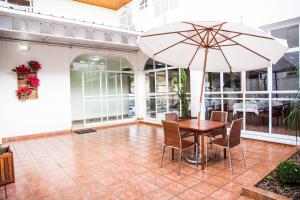 a table and chairs with an umbrella on a patio at Hotel Barrocos in Goiatuba