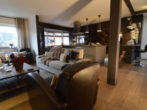 ein Wohnzimmer mit einem Sofa und einem Tisch sowie eine Küche in der Unterkunft Beautiful Apartment in Spa near Casino in Spa