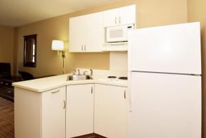 cocina con armarios blancos y nevera blanca en Extended Stay America Suites - Los Angeles - Chino Valley, en Chino