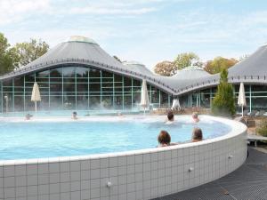 Personas sentadas en una piscina en un edificio. en Spa Apartment at ParkBlick, en Bad Dürrheim