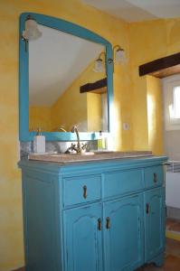 a bathroom sink with a mirror on top of it at Chambre d'hôtes Domaine de la Guinchère in LʼHôpital-le-Mercier