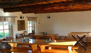 une salle à manger avec des tables en bois et des fenêtres dans l'établissement Aadu Holiday Farm, à Suur-Rootsi