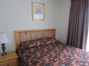 a bedroom with a bed and a picture on the wall at Schell Motel in Vernon