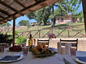 a table with a bowl of fruit and a bottle of wine at Farmhouse in Lazio with Lake Bolsena Views in Montefiascone