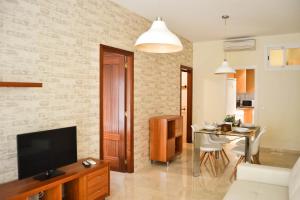 un salon avec une télévision et une table dans l'établissement Apartamento Ulises Suite 2, à Malaga