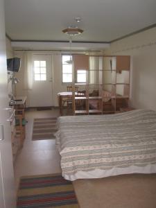 a bedroom with a bed and a dining room at Kalkpatronsgården Borgvik in Katthammarsvik