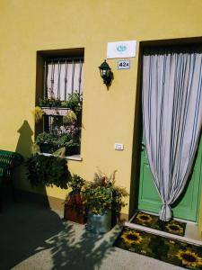 un edificio con una puerta con una cortina púrpura y flores en B&B Peschi in Fiore, en Valeggio sul Mincio