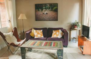 Sala de estar con sofá púrpura y mesa de centro en Casa Pocahullo en San Martín de los Andes