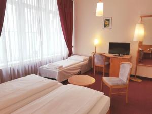 a hotel room with two beds and a television at Hotel Haydn in Vienna