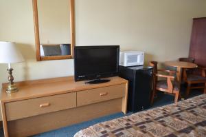 Habitación de hotel con TV en un tocador con cama en National 9 Inn Wellington, en Wellington