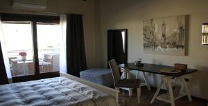 a bedroom with a bed and a desk and a table at B&B Martina in Assemini