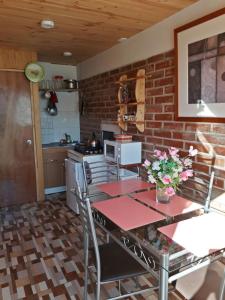 a kitchen with a table and a brick wall at Central 390 Isla Negra in Isla Negra