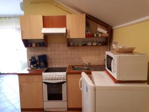 A kitchen or kitchenette at Rozmaring Apartmanok