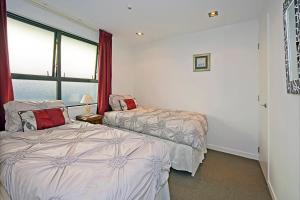 a bedroom with two beds and a large window at Waterfront Escape in Nelson
