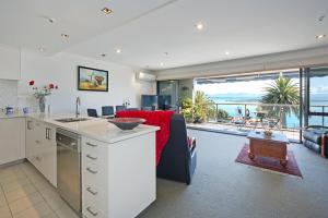 eine Küche und ein Wohnzimmer mit Meerblick in der Unterkunft Waterfront Escape in Nelson
